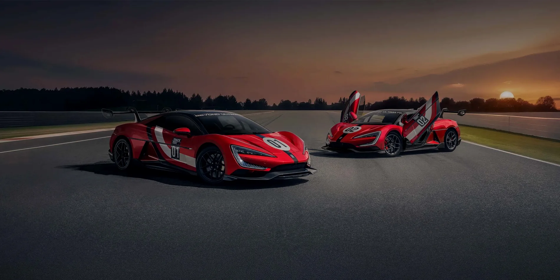 Two electric performance cars in competition livery on a circuit at sunset